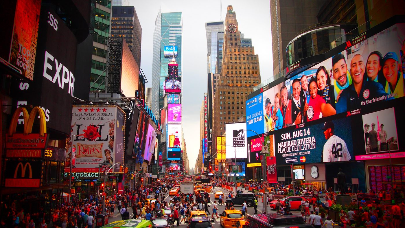 Large-format billboards and signage lighting up a city street